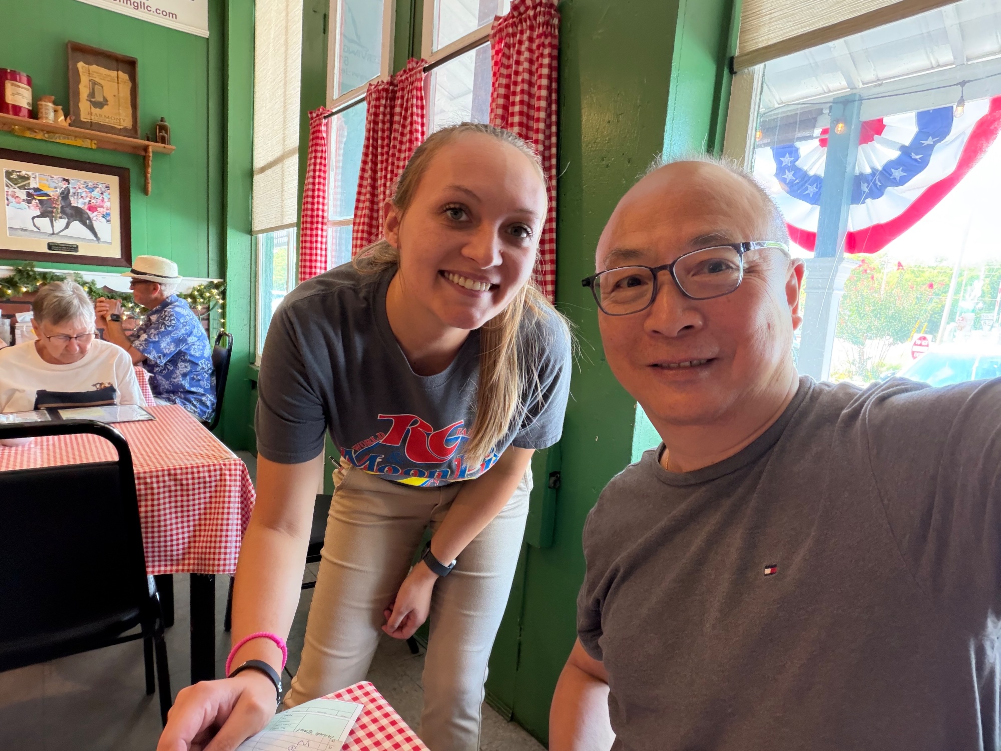 Selfie with a smiling waitress in a busy small town cafe